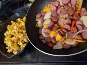 Cast iron pan with diced potatoes. Stir fry pan with kielbasa, peppers and onions.